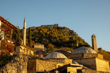 Bir tepenin yamacına kurulmuş kubbelerin ve kulelerin yer aldığı, zengin kültürel mirasın ve ışığın ve gölgenin etkileşiminin yer aldığı geleneksel mimarinin ilgi çekici bir görüntüsü..