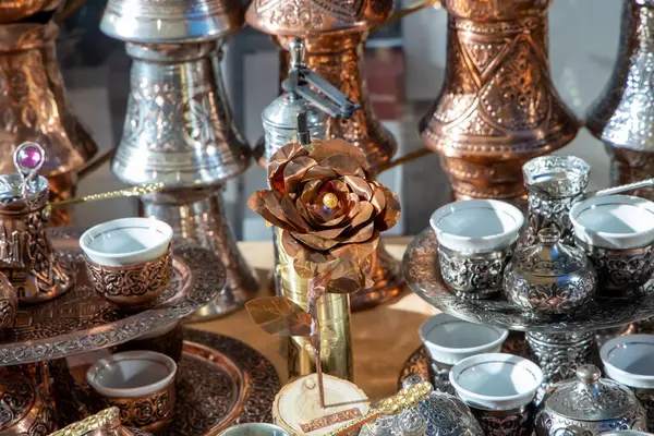 El yapımı bakır bir gülün yanı sıra, ustaca bir işçiliği ve romantik zarafeti temsil eden, karmaşık bir içki takımının da yer aldığı sanatsal bir gösteri..