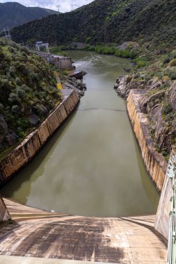 Baraj kanallarından geniş bir vadiye uzanan su yolu, verimli tepeler, mühendislik ve estetiğin bir başyapıtı tarafından çerçevelenir..