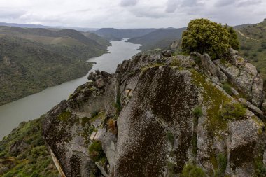 Görkemli kayalık uçurumlar ve canlı yeşilliklerle çevrili geniş bir panoramik nehir manzarası manzaranın ahengi ve ihtişamını gözler önüne seriyor..