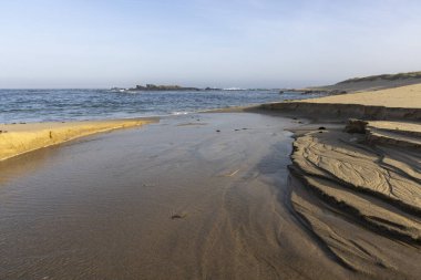 Görüntü yüksek açılı, kıyı lagününün uzak bir görüntüsünü gösteriyor. Göl sığ ve sakindir. Temiz suyun altında kumlu bir tabanı vardır. Sol tarafta kumlu bir sahil görünüyor..
