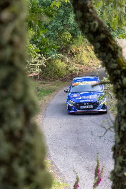 Ourense, İspanya, 13 Haziran 2025: Görüntüde dar, dolambaçlı bir dağ yolunda ilerleyen canlı mavi bir rali arabası görülüyor.