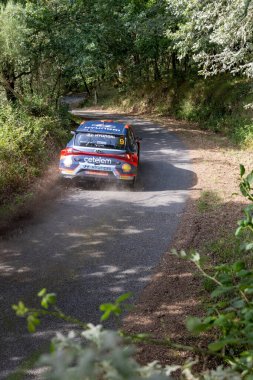 Bizimki, İspanya, 13 Haziran 2025, dar, çakıllı bir yolda keskin bir dönüş yapan ralli aracının orta açılı, orta ölçekli görüntüsü..