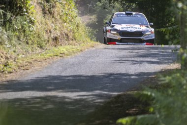 Ourense, İspanya, 13 Haziran 2025: Görüntü dar bir asfalt dağ yolunda keskin bir dönüş yapan ralli aracının yakın görüntüsünü sergiliyor.