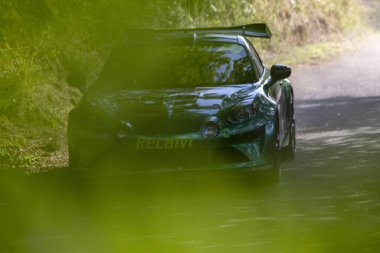 Ourense, İspanya, 13 Haziran 2025: Görüntü toprak bir yolda hareket halindeki bir ralli aracının yakın çekimini gösteriyor. Araba kısmen gizlenmiş..