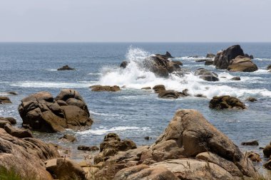 Okyanus sakin ve kayalar kıyı boyunca dağılmış. Dalgalar küçük ve naziktir. Huzurlu bir atmosfer yaratırlar.