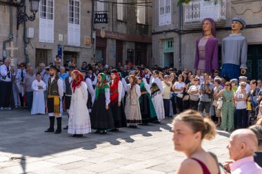Allariz, İspanya, 13 Temmuz 2025: Geleneksel kıyafetler giymiş bir grup insan sokakta yürüyor. Sahne canlı ve renkli, birçok insan şapka takıyor ve enstrüman taşıyor..