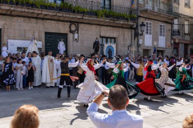 Allariz, İspanya, 13 Temmuz 2025: Bir grup insan geçit töreninde dans ediyor. İnsanlar renkli kıyafetler giyiyorlar ve geleneksel kıyafetler giyiyorlar..