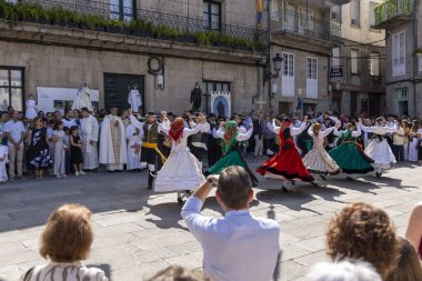 Allariz, İspanya, 13 Temmuz 2025: Bir grup insan geçit töreninde dans ediyor. İnsanlar renkli kıyafetler giyiyorlar ve geleneksel kıyafetler giyiyorlar..