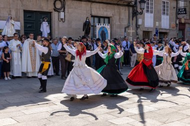 Allariz, İspanya, 13 Temmuz 2025: Bir grup insan geçit töreninde dans ediyor. İnsanlar renkli kıyafetler giyiyorlar ve geleneksel kıyafetler giyiyorlar..