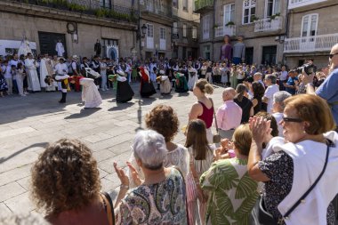 Allariz, İspanya, 13 Temmuz 2025: Bir grup insan geçit töreninde dans ediyor. İnsanlar renkli kıyafetler giyiyorlar ve geleneksel kıyafetler giyiyorlar..