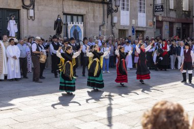 Allariz, İspanya, 13 Temmuz 2025: Bir grup insan geçit töreninde dans ediyor. İnsanlar renkli kıyafetler giyiyorlar ve geleneksel kıyafetler giyiyorlar..