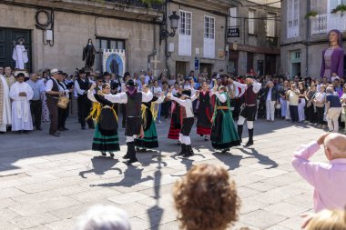 Allariz, İspanya, 13 Temmuz 2025: Bir grup insan geçit töreninde dans ediyor. İnsanlar renkli kıyafetler giyiyorlar ve geleneksel kıyafetler giyiyorlar..