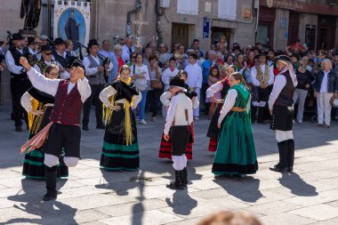 Allariz, İspanya, 13 Temmuz 2025: Bir grup insan geçit töreninde dans ediyor. İnsanlar renkli kıyafetler giyiyorlar ve geleneksel kıyafetler giyiyorlar..