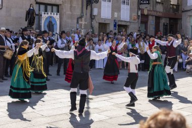 Allariz, İspanya, 13 Temmuz 2025: Bir grup insan geçit töreninde dans ediyor. İnsanlar renkli kıyafetler giyiyorlar ve geleneksel kıyafetler giyiyorlar..