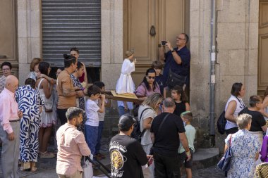 Allariz, İspanya, 13 Temmuz 2025: Büyük bir heykel taşıyan bir grup insan. İnsanlar siyah ve beyaz giyinmiş ve heykel çiçeklerle çevrili..