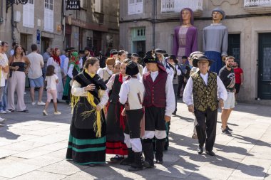 Allariz, İspanya, 13 Temmuz 2025: Geleneksel kıyafetler giymiş bir grup insan sokakta yürüyor. Manzara canlı ve şenlikli.