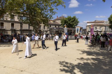 Allariz, İspanya, 13 Temmuz 2025: Beyaz cüppeli bir adam kalabalığın önünde duruyor. Adamın elinde haç var ve o bir rahip..