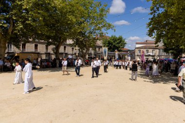 Allariz, İspanya, 13 Temmuz 2025: Beyaz cüppeli bir adam kalabalığın önünde duruyor. Adamın elinde haç var ve o bir rahip. Kalabalık her yaştan insandan oluşuyor..