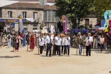 Allariz, İspanya, 13 Temmuz 2025: Beyaz cüppeli bir grup genç caddede yürüyor. Adamlar enstrüman taşıyor ve yürüyor gibi görünüyorlar.