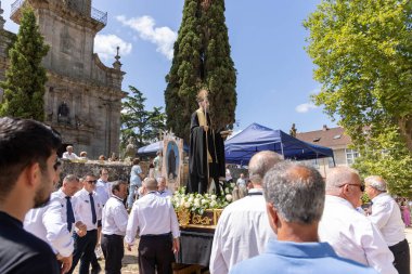 Allariz, İspanya, 13 Temmuz 2025: Büyük bir grup insan büyük bir heykelle sokakta yürüyorlar.