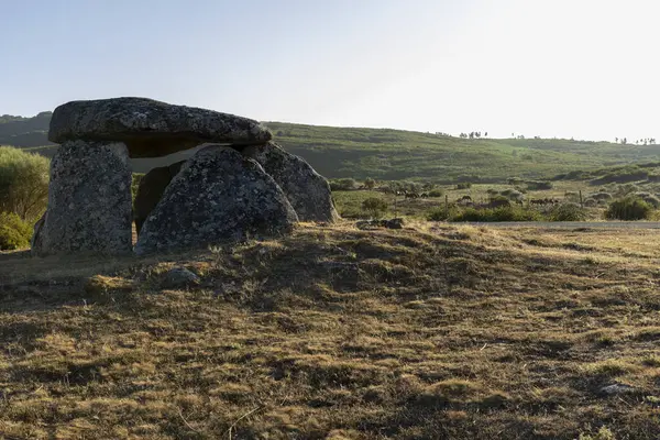 Büyük bir kaya yapısı kuru otların olduğu bir alanda bulunur. Bina kayalık bir yamaçla çevrili ve o bir mağara. Sahne sessiz ve huzurlu, insan aktivitesi belirtisi yok.