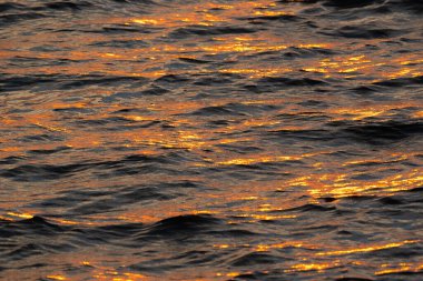 Gün batımında deniz ve okyanusun yüzeysel sularının soyut fotoğrafı