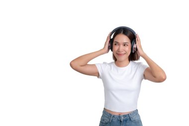 Asyalı, Taylandlı, beyaz gömlekli genç bir kadın. Kulaklıklı müzik dinliyor.