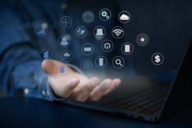 İş adamı dizüstü bilgisayarla çalışır ekranda yüzen dijital ve tekoloji simgesini arar