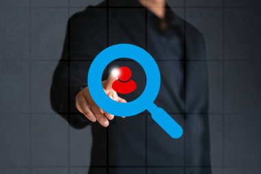 İş adamı yeni bir iş simgesi bulmak için dizüstü bilgisayarla çalışıyor. Tablet ekranında yüzüyor