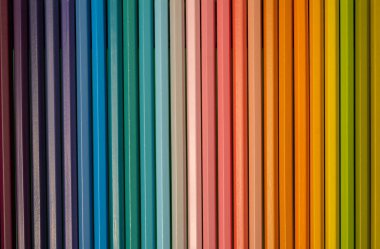 Sıraya dizilmiş renkli kalemlerin yakın plan fotoğrafı.