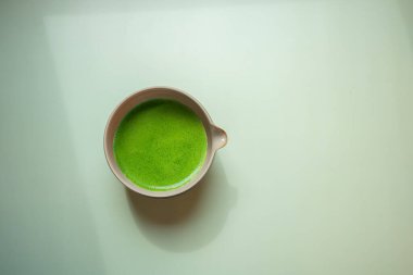 Pastel yeşil arka planda kibrit yeşil çay, durgun bir yaşam tarzında çekilmiş..