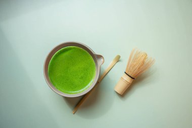 Pastel yeşil arka planda kibrit yeşil çay, durgun bir yaşam tarzında çekilmiş..