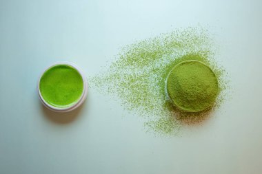 Pastel yeşil arka planda kibrit yeşil çay, durgun bir yaşam tarzında çekilmiş..