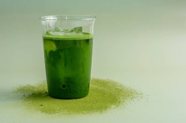 Pastel yeşil arka planda kibrit yeşil çay bardağı, durgun yaşam tarzında çekilmiş..