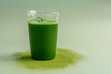 Pastel yeşil arka planda kibrit yeşil çay bardağı, durgun yaşam tarzında çekilmiş..