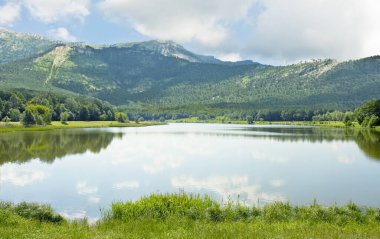 Yazın tepeler ve göl manzarası.