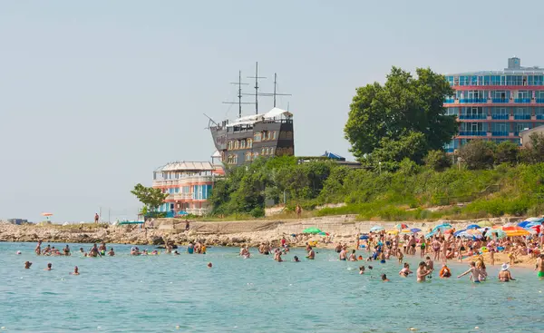 02 Temmuz 2015 - St. ConstANTINE VE HELENA RESORT, VARNA REJON, BULGARIA: Yelkenli gemi Sirius ve otel Sirius 'taki restoran ve yazın sahilde yüzen insanlar.