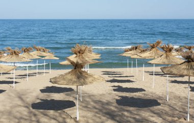 Bulgaristan 'ın Saint Constantine ve Helena tatil beldelerinin plajlarında egzotik plaj şemsiyeleri.