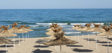 Bulgaristan 'ın Saint Constantine ve Helena tatil beldelerinin plajlarında egzotik plaj şemsiyeleri.