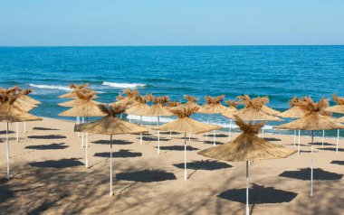 Bulgaristan 'ın Saint Constantine ve Helena tatil beldelerinin plajlarında egzotik plaj şemsiyeleri.