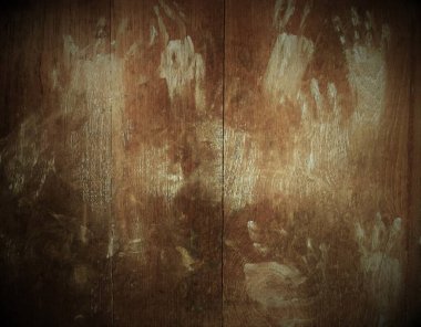 Small child's handwriting smeared with talcum powder stamped on old wooden door