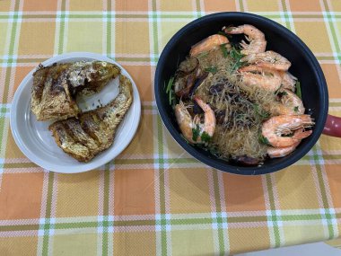 Vermicelli kızarmış balık ve masada karides.