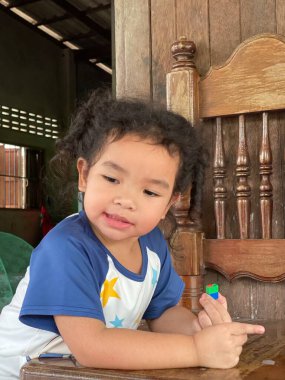 Sandalyede oturan ve bir şeyi işaret eden tatlı Asyalı kız.