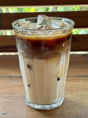 Ahşap bir masada arka planı bulanık buzlu bir kahve.