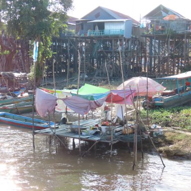 Kamboçya 'nın fakir yüzen köyü, tahta bacaklı evler ve Asya' da bir sürü çöp.