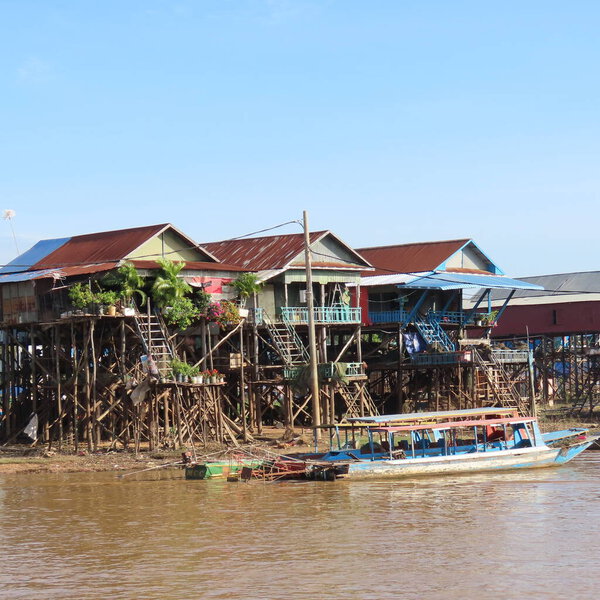 poor floating village in Cambodia, houses on stilts and lots of garbage in asia