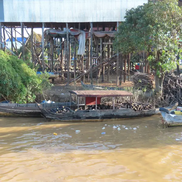 Kamboçya 'nın fakir yüzen köyü, tahta bacaklı evler ve Asya' da bir sürü çöp.