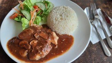 Tabakta salata ve koyu soslu et.