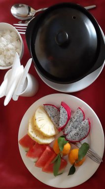 Kırmızı masa örtüsü üzerinde bir tabak meyveli çorba.